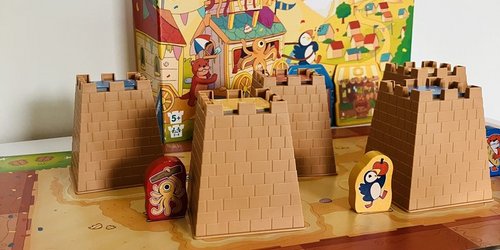 Für Baukunst-Fans sorgt „Die Sandburgen von Burgund“ für Spaß (Foto: Kreis Coesfeld) Auf einem Tisch ist ein Brettspiel mit Burgen, Spielsteienen und Würfeln aufgebaut. Dahinter steht ein Spielkarton, auf dem "Die Sandburgen von Burgund" steht.