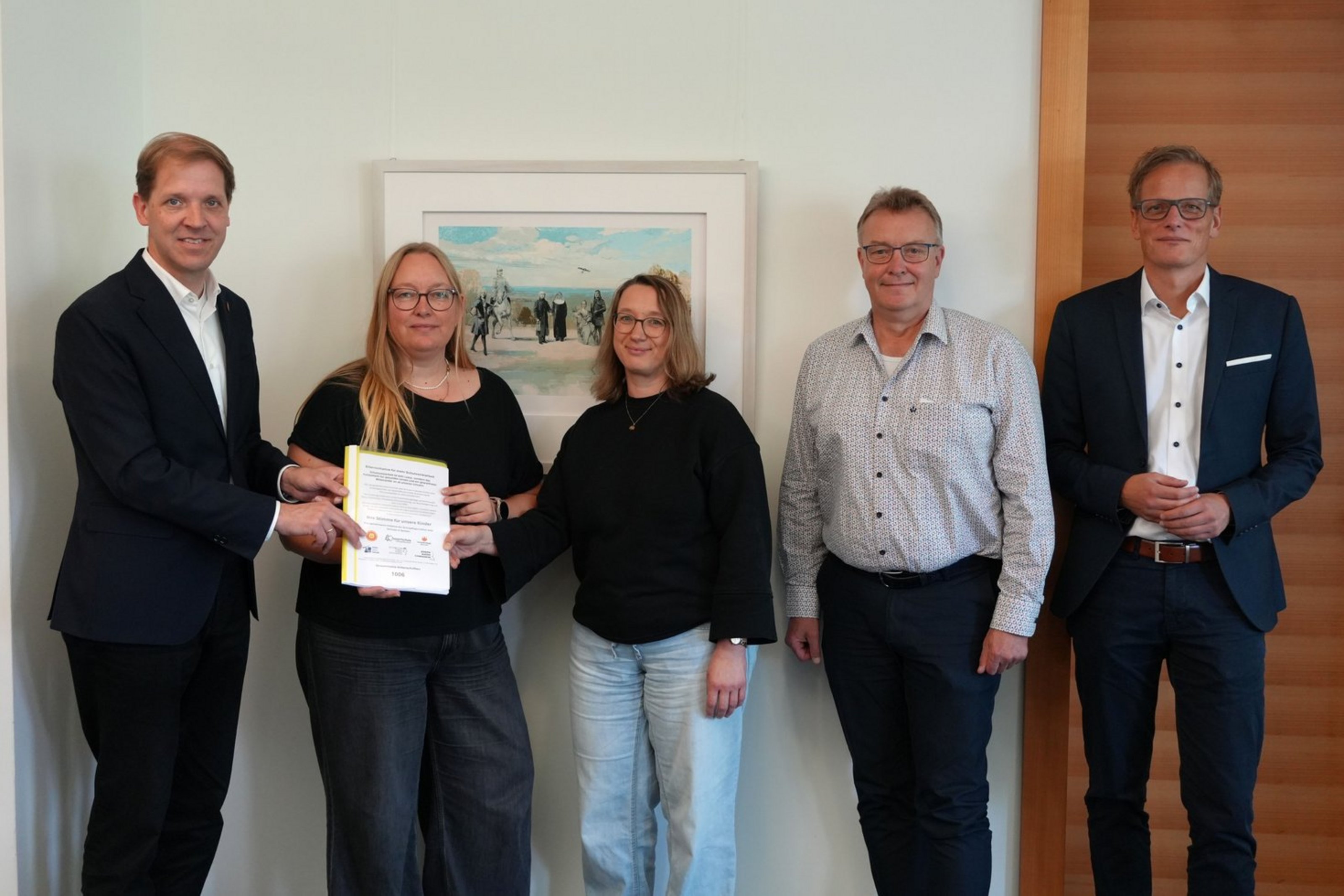 Fünf Personen präsentieren gemeinsam die übergebenen Unterschriftenlisten zur Schulsozialarbeit in Coesfeld.