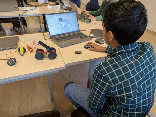 Ein Junge sitzt vor einem Laptop. 