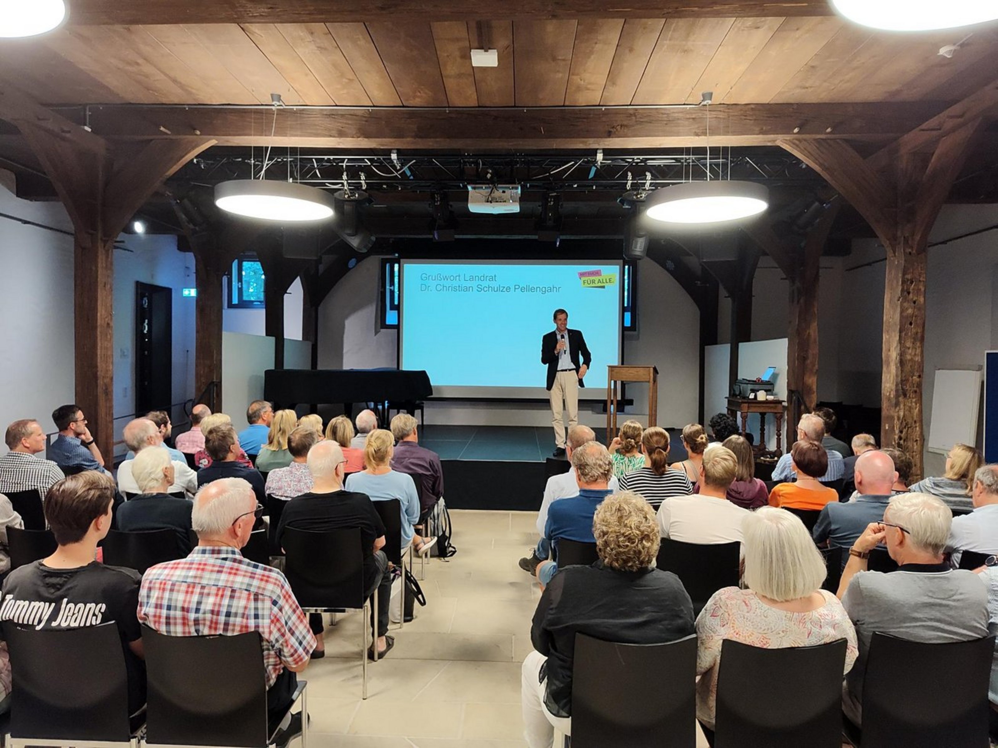Workshop der Deutschen Stiftung für Engagement und Ehrenamt (DSEE) auf der Burg Vischering (Foto: Kreissportbund, Jens Wortmann). Ein Mann steht auf einer Bühne und redet vor einem Publikum.