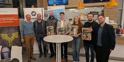 Gruppe von Teilnehmenden und Organisatoren steht im Bistro Orange in Dülmen beim Info-Abend zur beruflichen Orientierung.