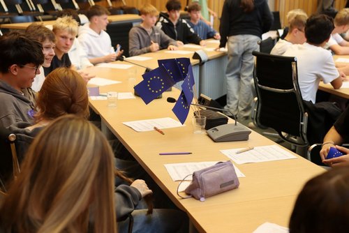 Schülerinnen und Schüler sitzen in Gruppen und diskutieren engagiert über ihre Ideen für ein aktives Europa.