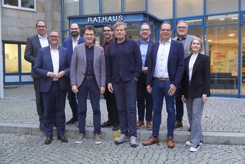 Gruppe von Vertreterinnen und Vertretern der NRW-Regionen steht vor dem Rathaus in Lingen und trifft sich dort zum Austausch mit Oberbürgermeister Dieter Krone und der Wirtschaftsförderung Lingen.