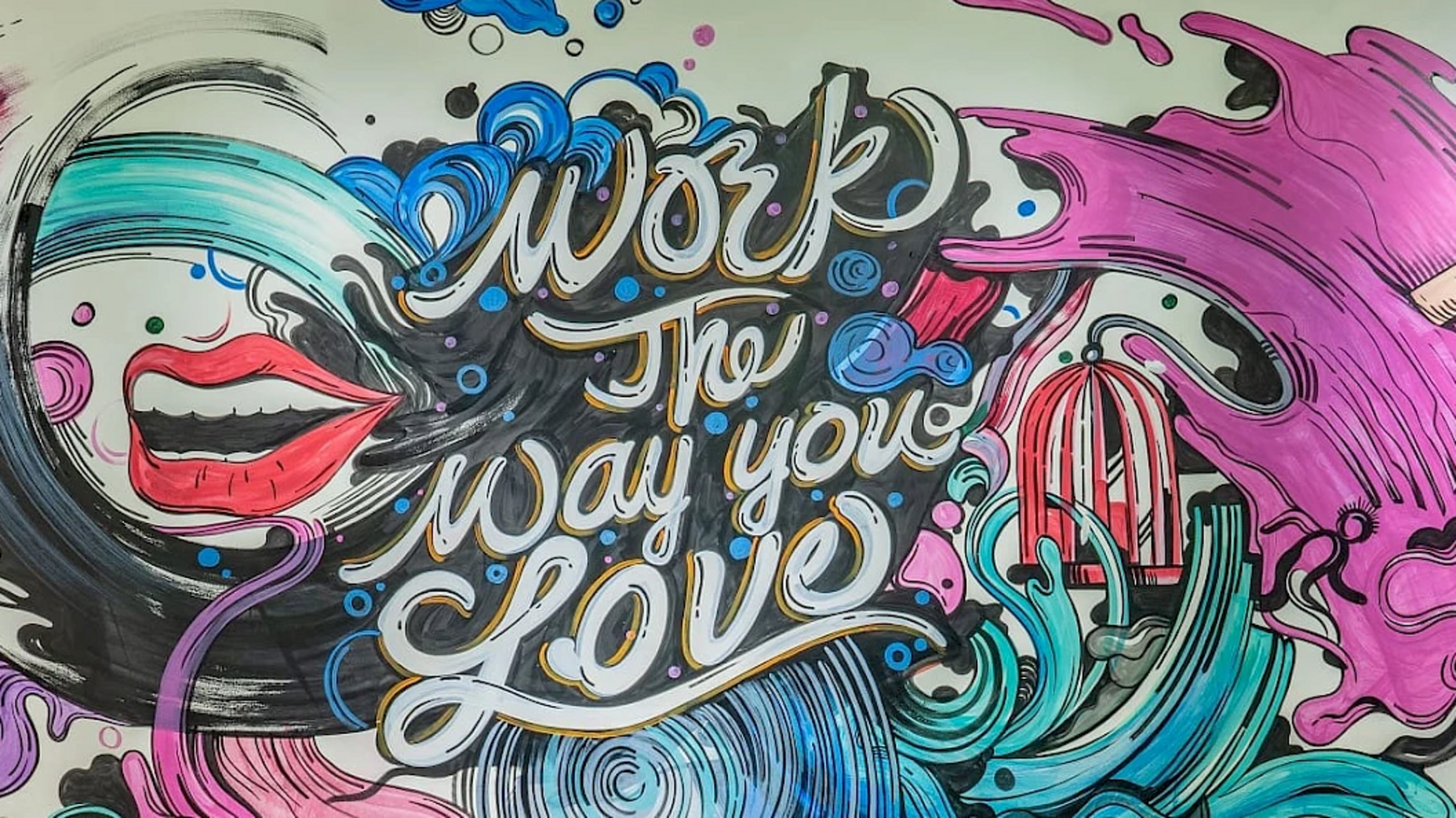Bunte Wandgrafik mit einem offenen Mund, blauen Wellen, einer roten Vogelkäfig-Silhouette und dem Schriftzug 'work the way you love' in geschwungener Schrift