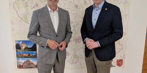 Landrat Dr. Christian Schulze Pellengahr (rechts) und FMO-Geschäftsführer Andrés Heinemann vor einer Kreiskarte