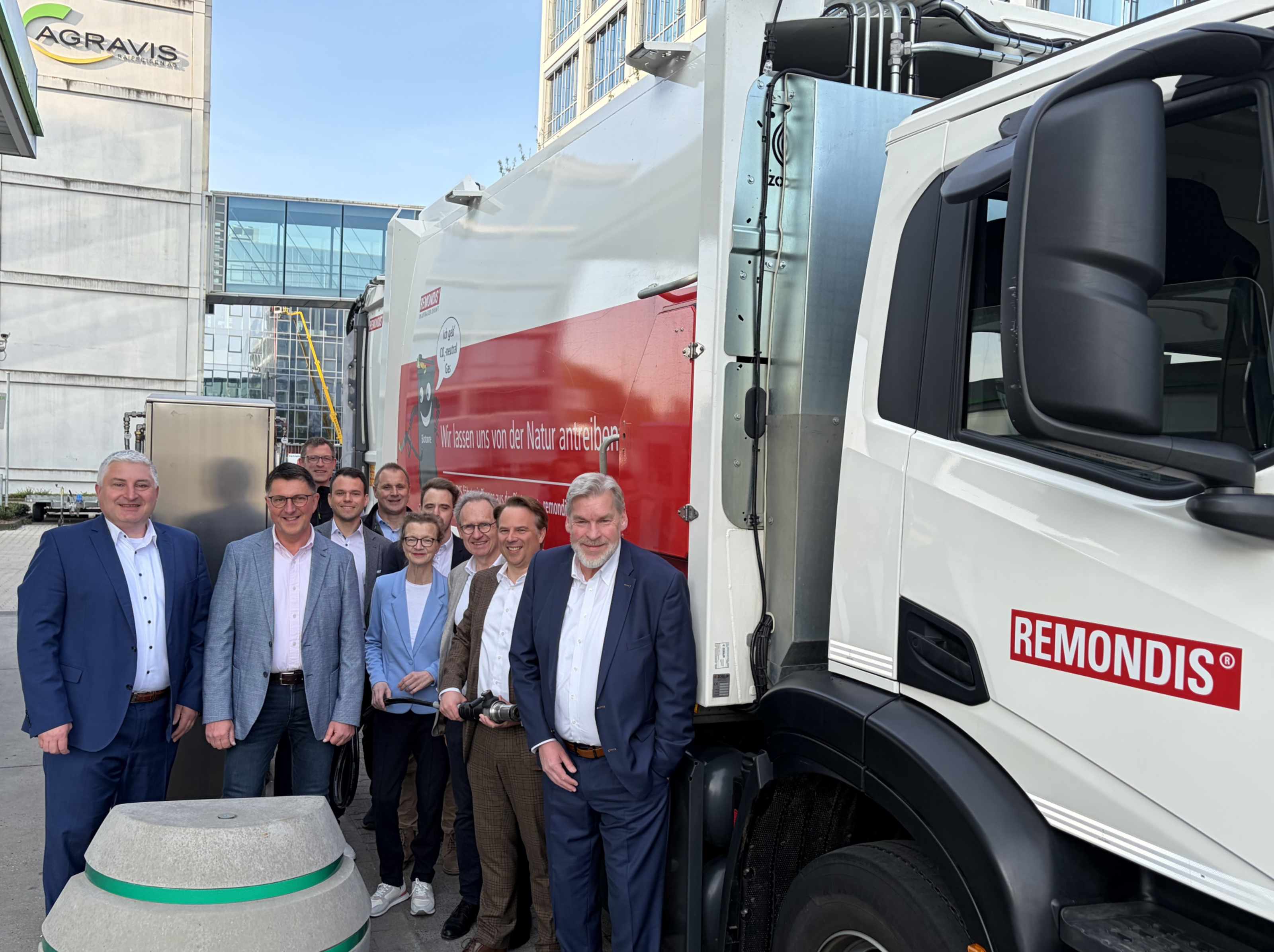 Zehn Personen stehen neben einem großen LKW mit der Aufschrift "REmondis. Wir lassen uns von der Natur antrieben."