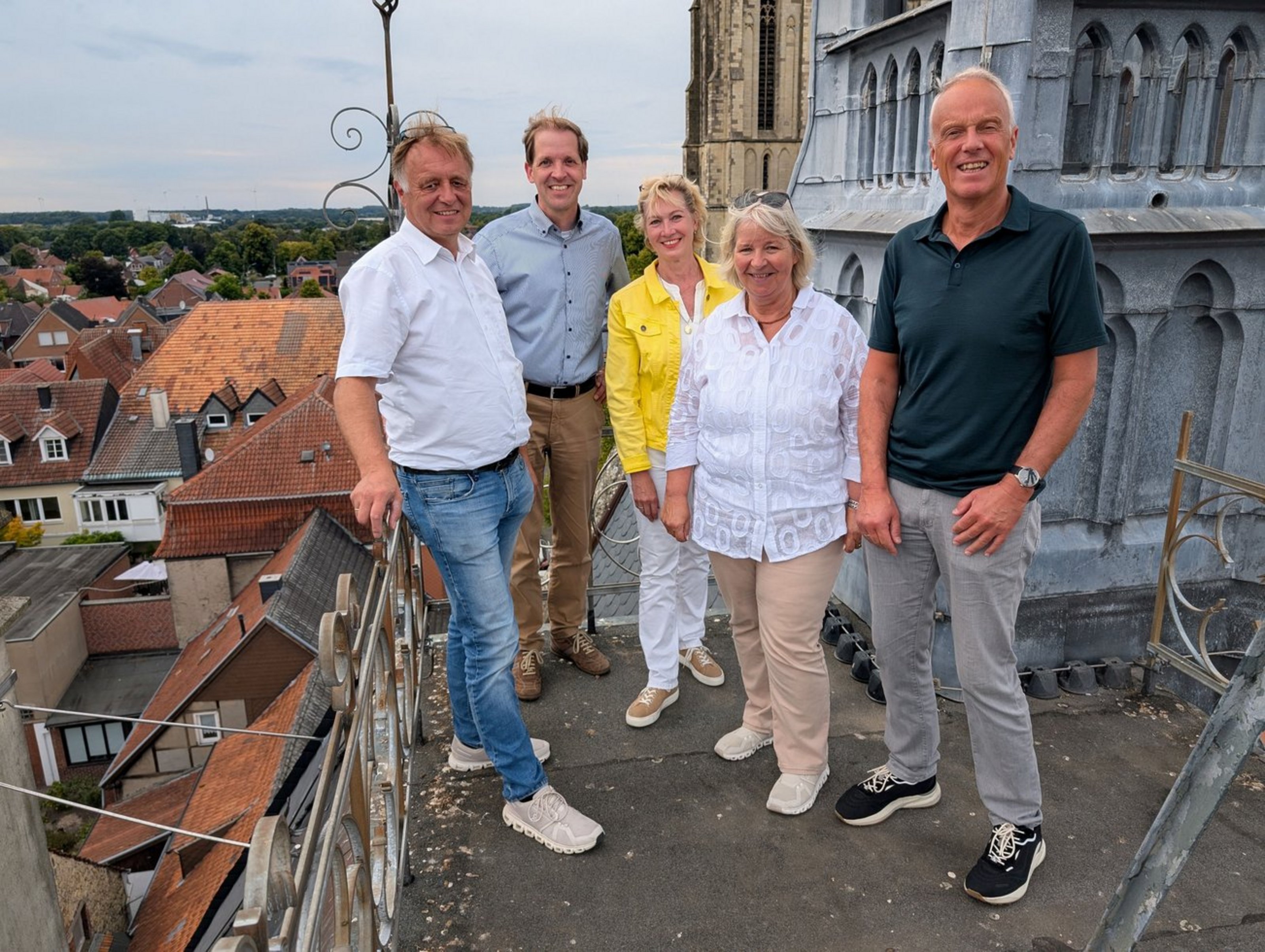 Landrat Dr. Christian Schulze Pellengahr bei der ersten Station der Sommertour in Billerbeck (Foto: Kreis Coesfeld). Fünf Personen stehen auf dem Dach eines Gebäudes. Im Hintergrund sind Dächer zu sehen.