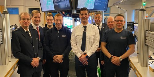 Landrat Dr. Christian Schulze Pellengahr steht an Heiligabend gemeinsam mit Mitarbeitenden in der Rettungsleitstelle des Kreises Coesfeld vor Einsatzmonitoren.