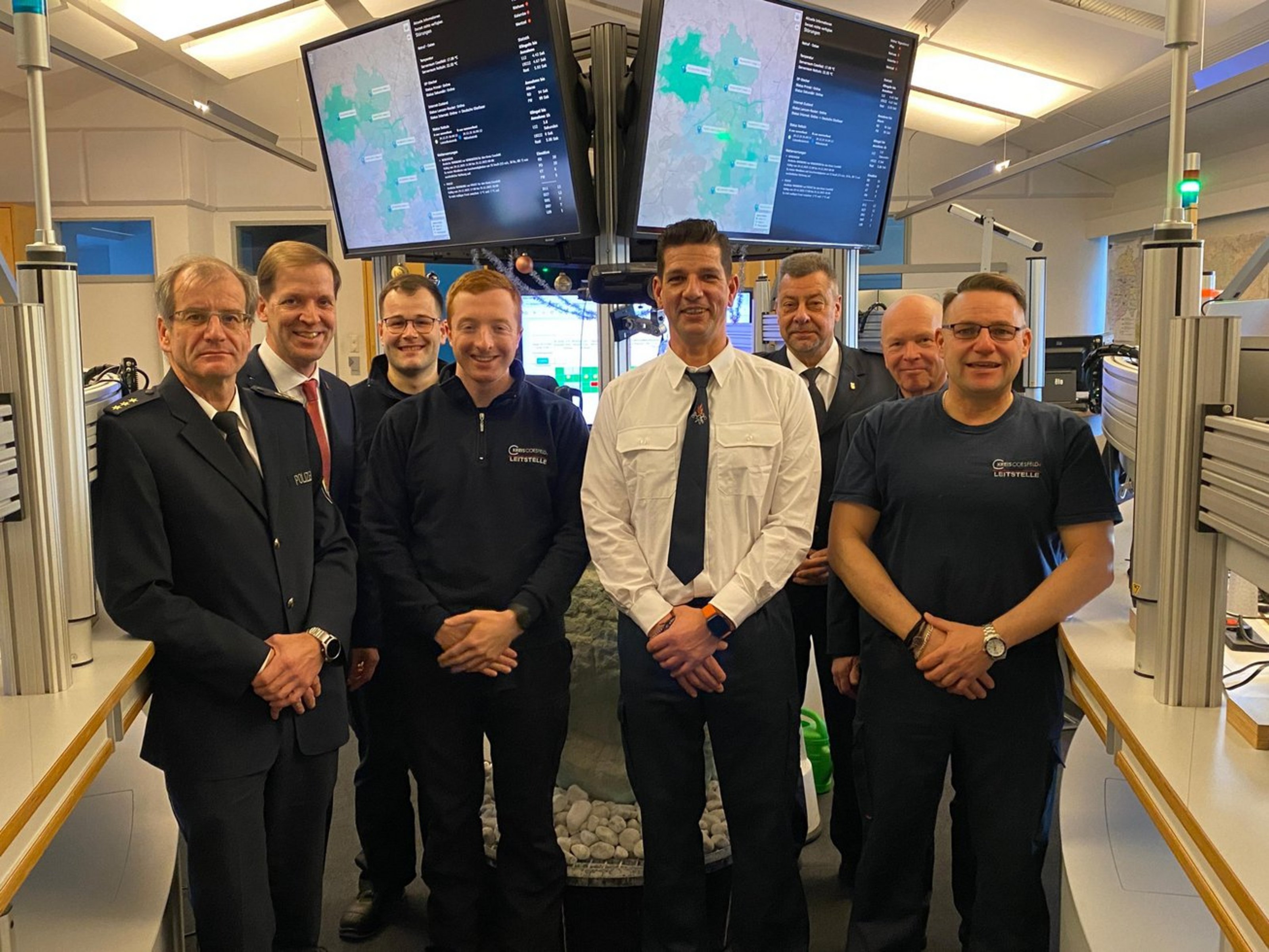 Landrat Dr. Christian Schulze Pellengahr steht an Heiligabend gemeinsam mit Mitarbeitenden in der Rettungsleitstelle des Kreises Coesfeld vor Einsatzmonitoren.