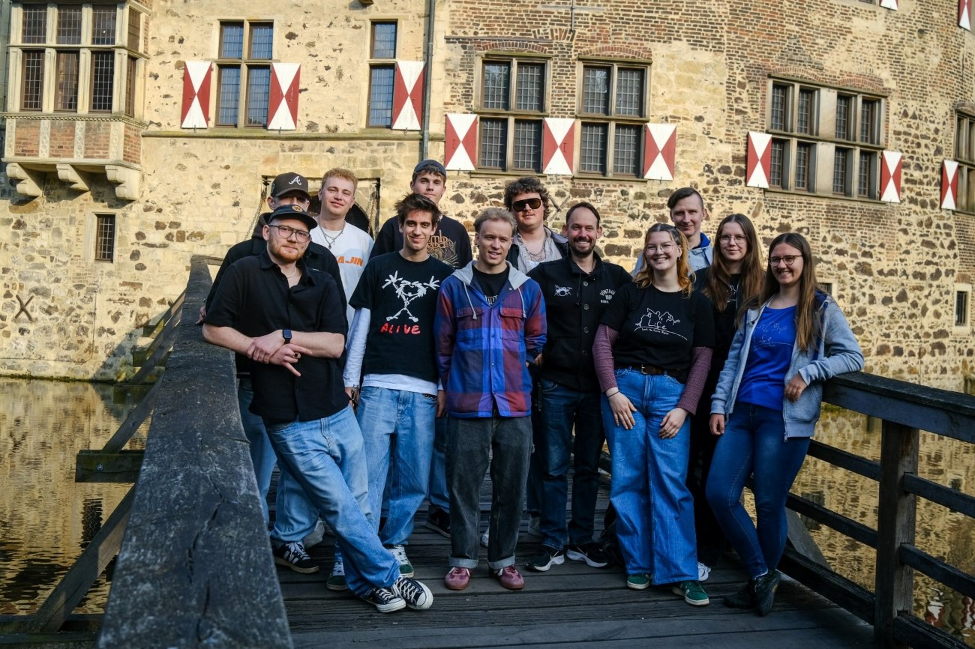 Gruppenfoto der Bands Tante Emma, Soul Kite und Life Band auf einer Holzbrücke vor Burg Vischering.