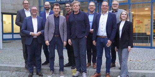 Gruppe von Vertreterinnen und Vertretern der NRW-Regionen steht vor dem Rathaus in Lingen und trifft sich dort zum Austausch mit Oberbürgermeister Dieter Krone und der Wirtschaftsförderung Lingen.