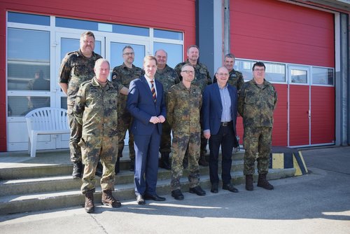 Mehrere Soldaten und Vertreter aus Politik stehen während einer Übung des Kreisverbindungskommandos vor einem Gebäude in Dülmen.