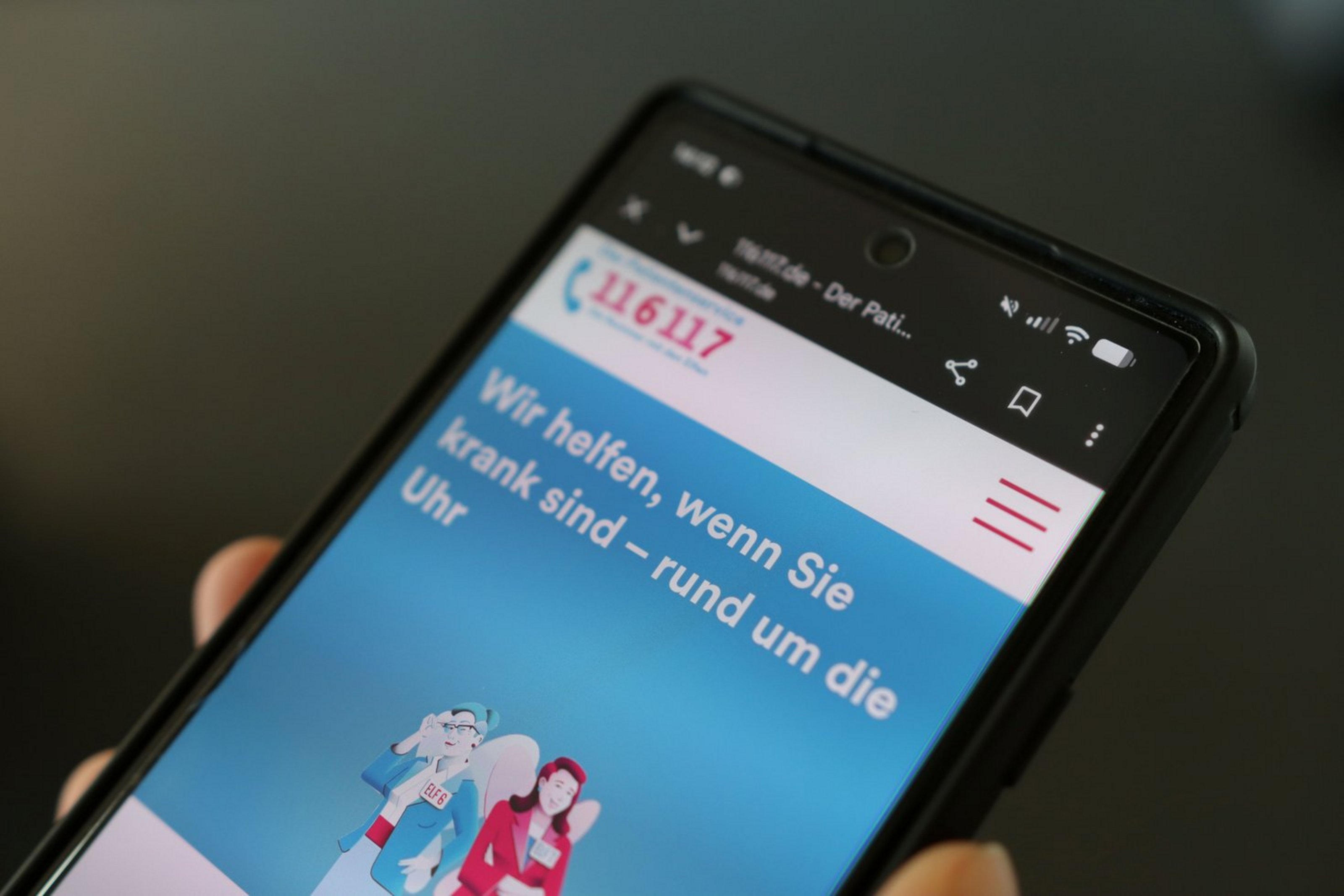Auf einem Mobiltelefon ist die Website des Patientenservice 116 117 geöffnet.