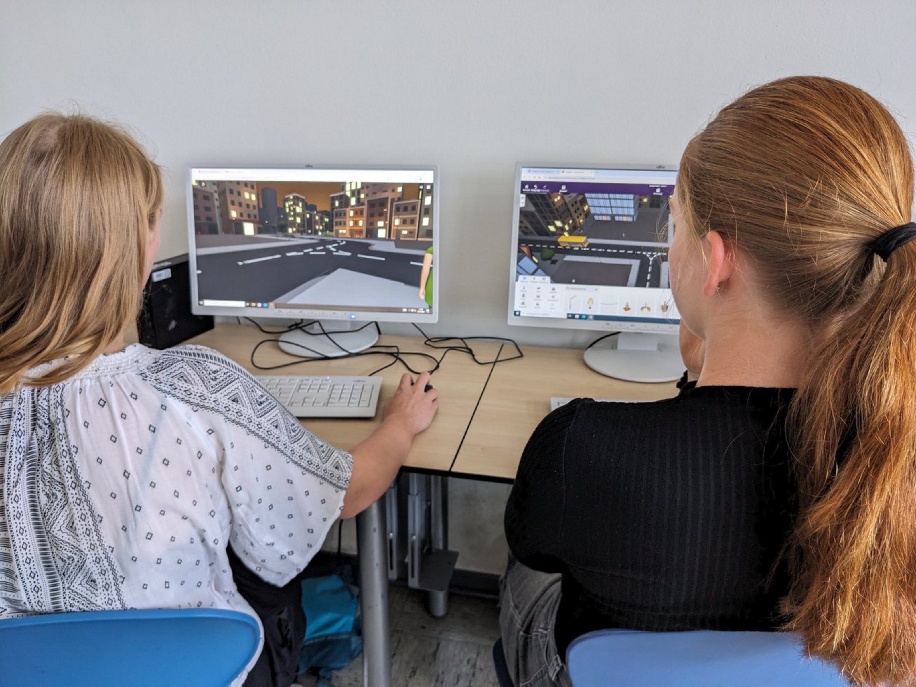Zwei Schülerinnen programmieren am Computer eine virtuelle Spieleumgebung.