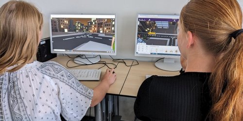 Zwei Schülerinnen programmieren am Computer eine virtuelle Spieleumgebung.