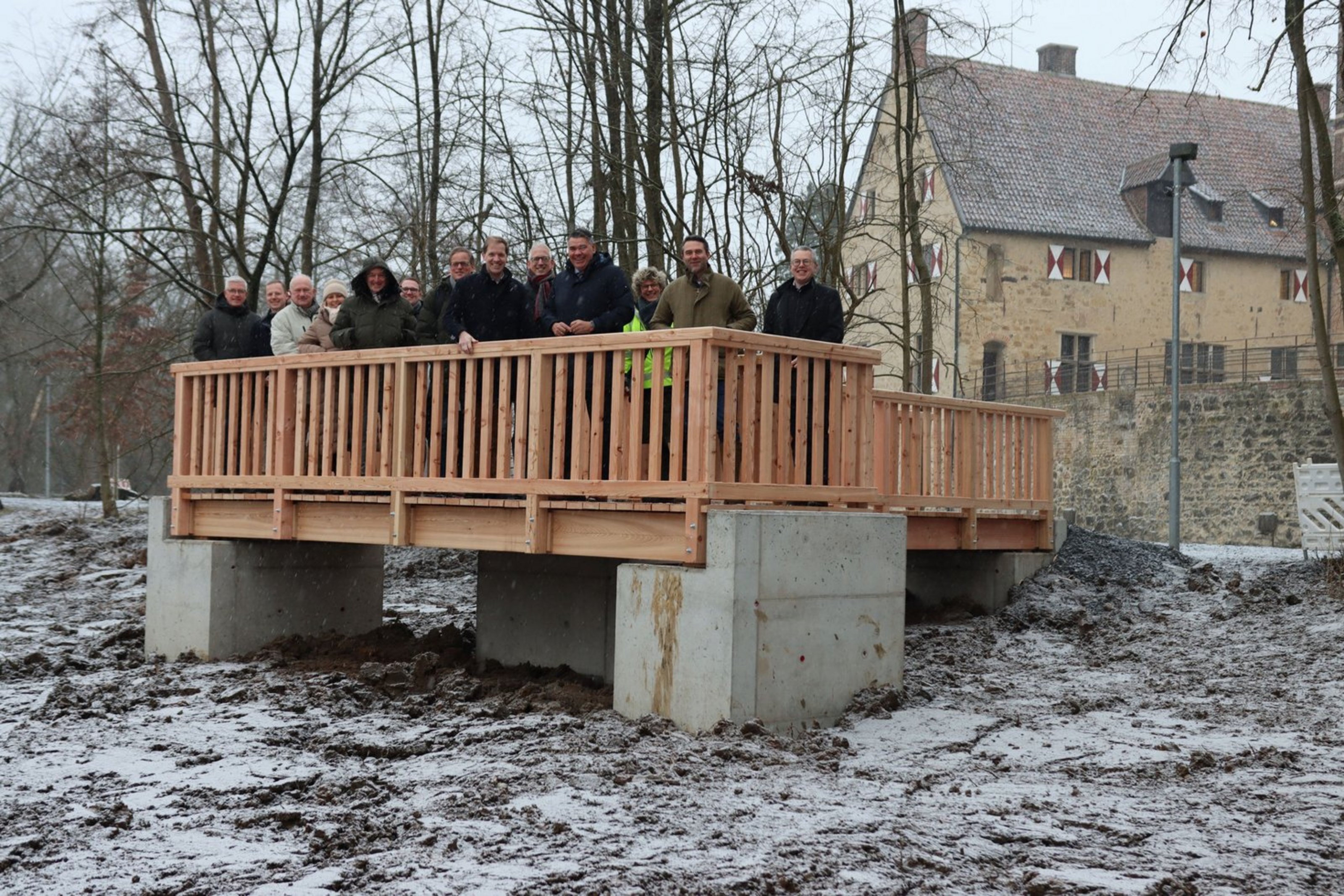 Eine Gruppe von Menschen auf einem Aussichtssteg vot einer Burg.