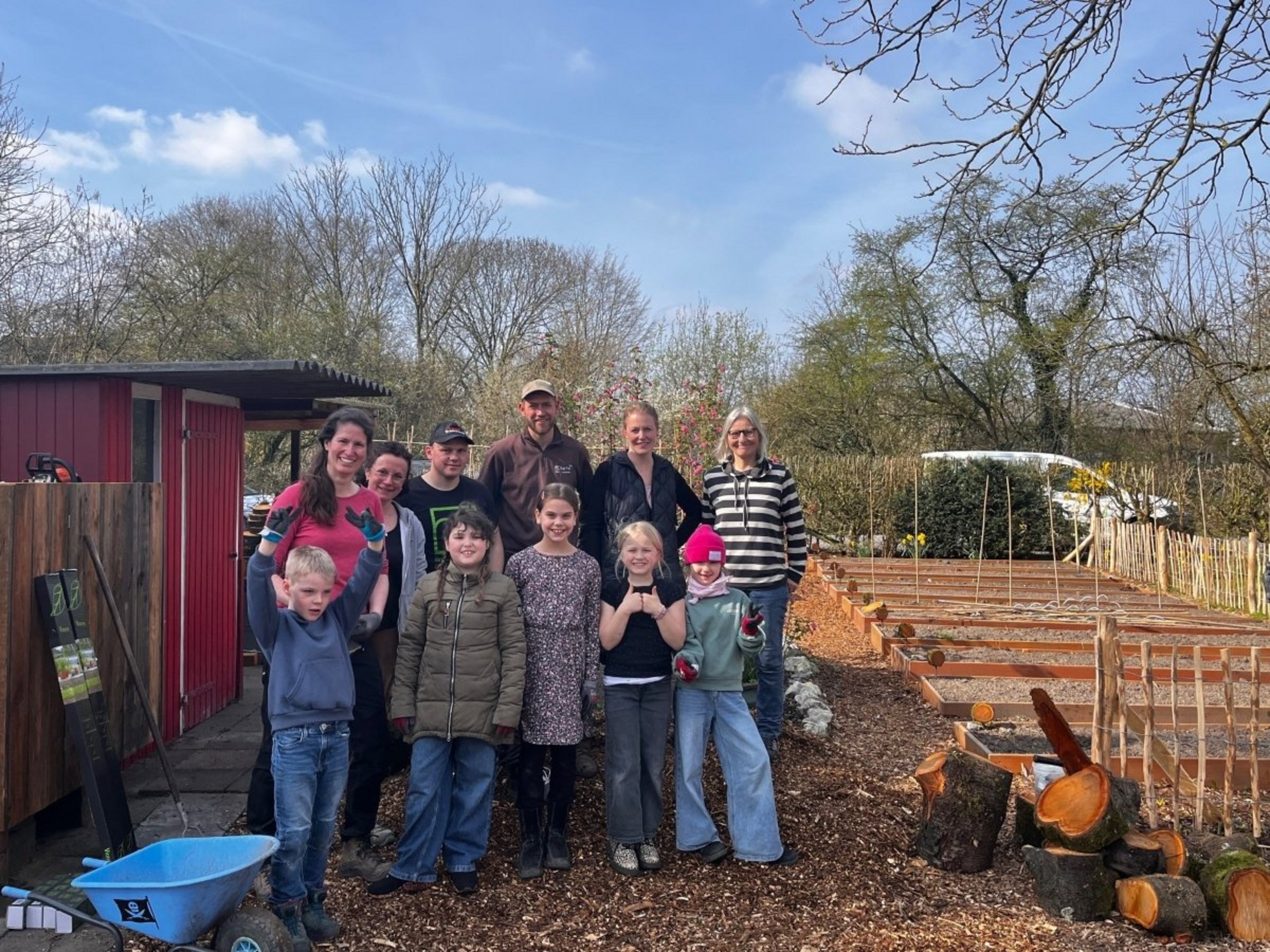 Schülerinnen, Schüler und Erwachsene vor dem neuen Gemüsegarten der Montessori Schule