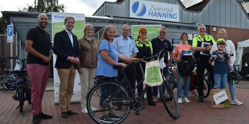 Drei Gewinnerinnen präsentieren gemeinsam mit Vertreterinnen und Vertretern von Kreis, Polizei und Zweirad Hanning ihre Preise des Verkehrsquiz.