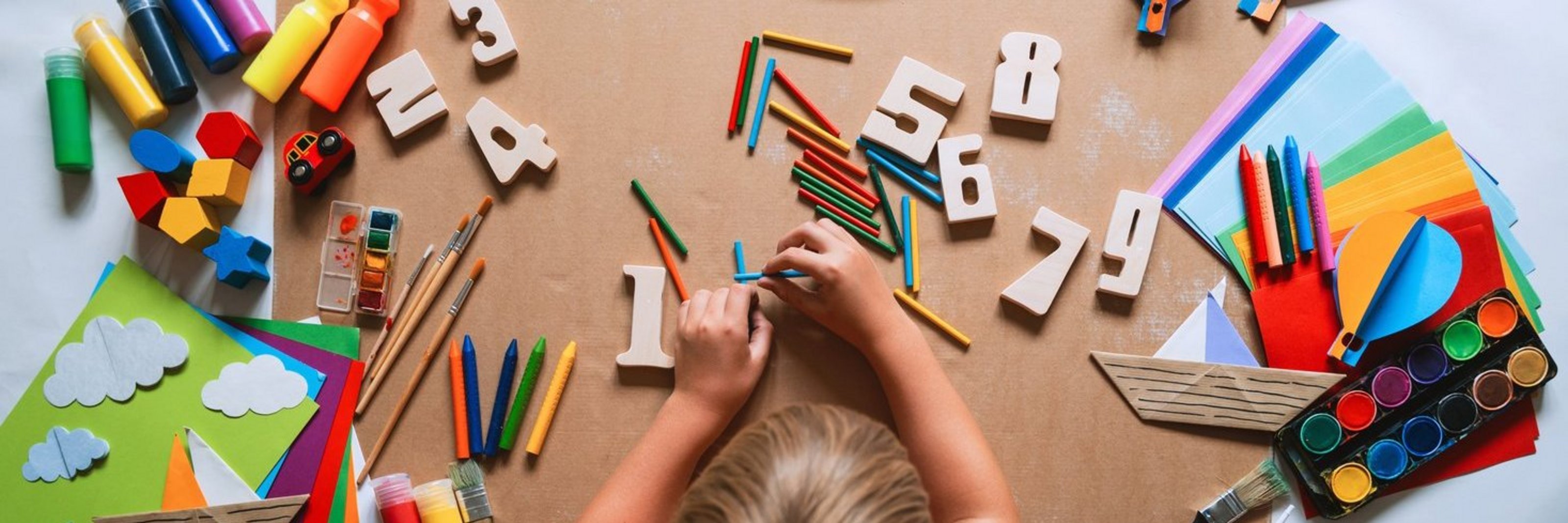 Child drawing and making crafts in school or daycare.