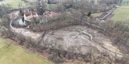 Eine Luftaufnahme zeigt eine Wasserburg.