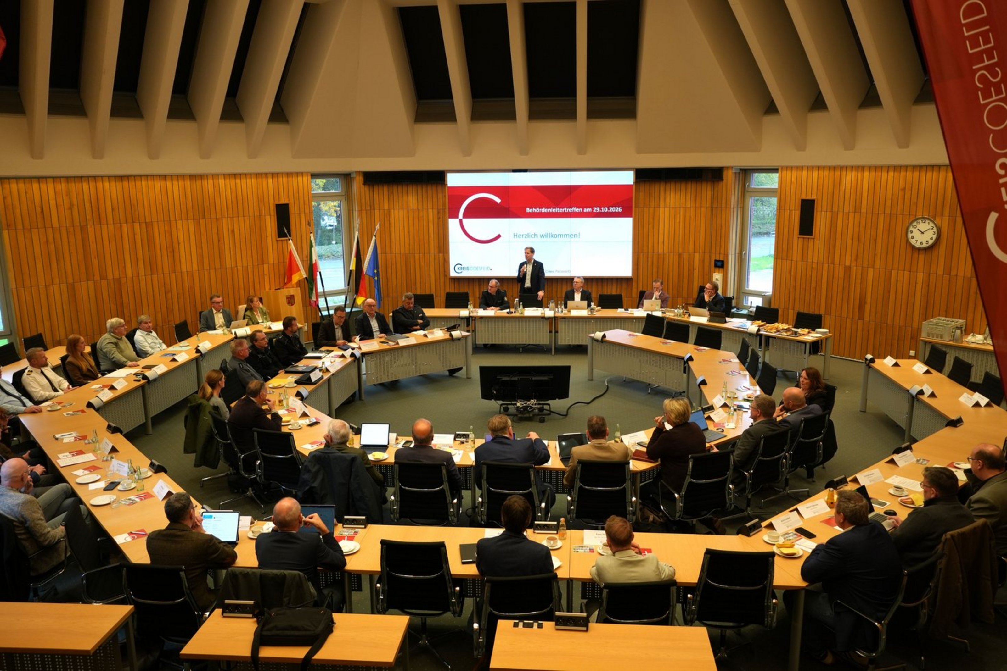 Landrat Dr. Christian Schulze Pellengahr eröffnet stehend das Behördenleitertreffen und die Sicherheitskonferenz vor den versammelten Teilnehmenden.