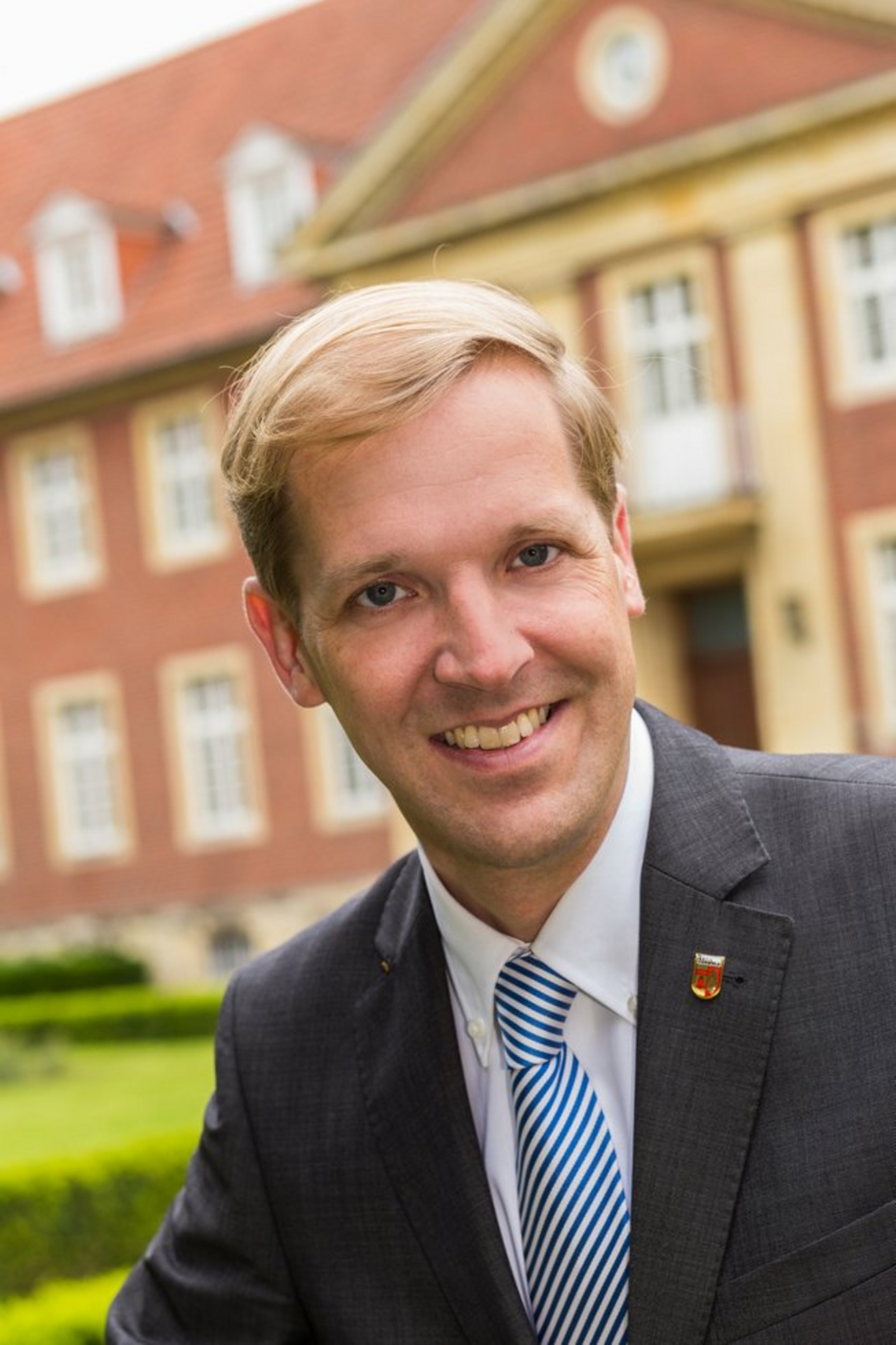 Porträt von Landrat Dr. Christian Schulze Pellengahr vor einem historischen Gebäude.