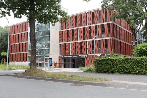 Außenansicht des neuen Parkhauses „Altes Freibad“ mit moderner Ziegelfassade und Einfahrt.