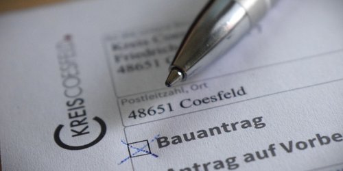 Das Foto zeigt die Nahaufnahme eines Bauantrags, auf dem ein Kugelschreiber liegt.