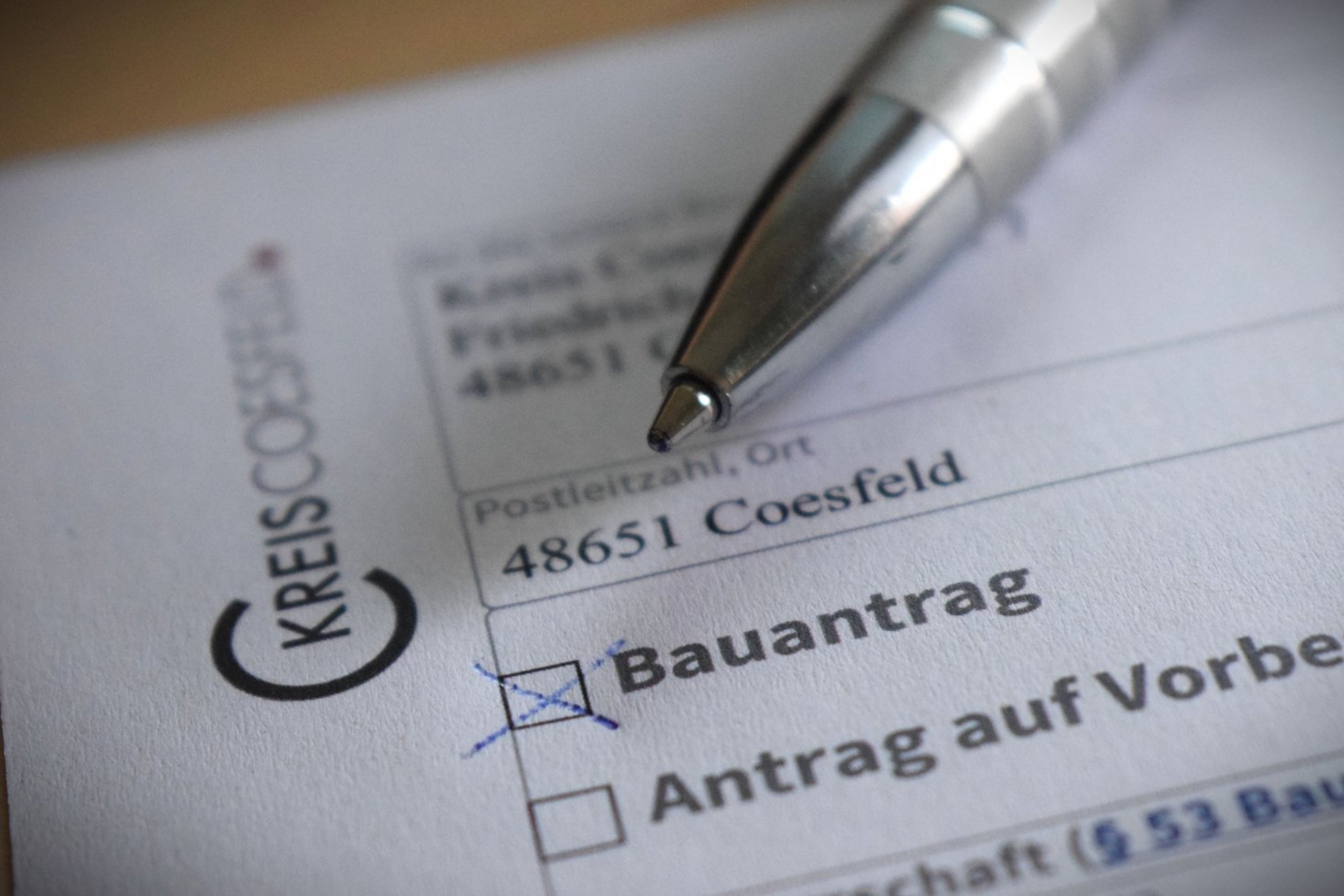 Das Foto zeigt die Nahaufnahme eines Bauantrags, auf dem ein Kugelschreiber liegt.