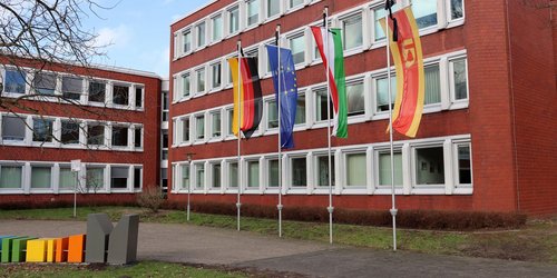 Fahnen vor dem Kreishaus Coesfeld hängen mit Trauerflor als Zeichen der Trauerbeflaggung.