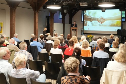 Ehrenamtliche Betreuerinnen und Betreuer sitzen bei einer Dankeschönveranstaltung auf Burg Vischering im Publikum.