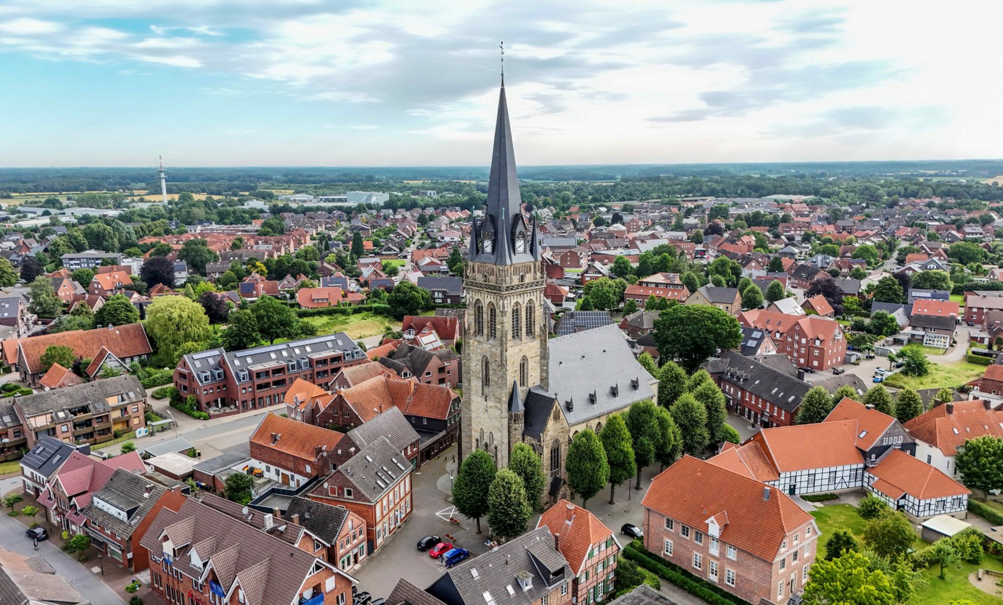 Man sieht von oben eine Kirche mit hohem Kirchturm.