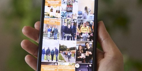 Auf einem Handybildschirm, der von einer Hand gehalten wird, ist ein Raster mit drei mal vier Fotos zu sehen.